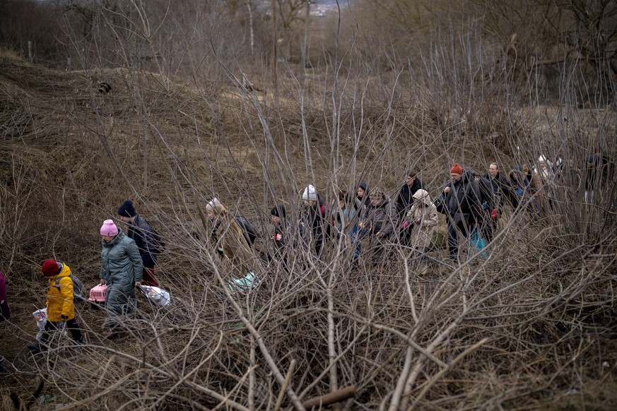 Ukrainian citizens flee crossing the Irpin river in the outskirts of Kyiv, Ukraine, Saturday, March 5, 2022. (AP Photo/Emilio Morenatti)