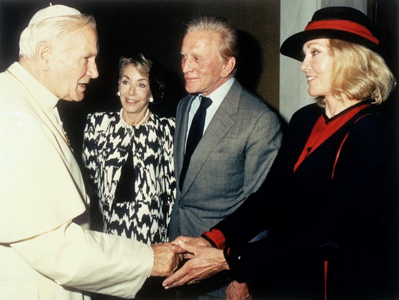 Pope John Paul II shakes hands with American actress Kim Novak as actor Kirk Douglas and his wife Anne Buydens look on during a private audience at the Vatican, June 21, 1989. They were in Italy to be ...