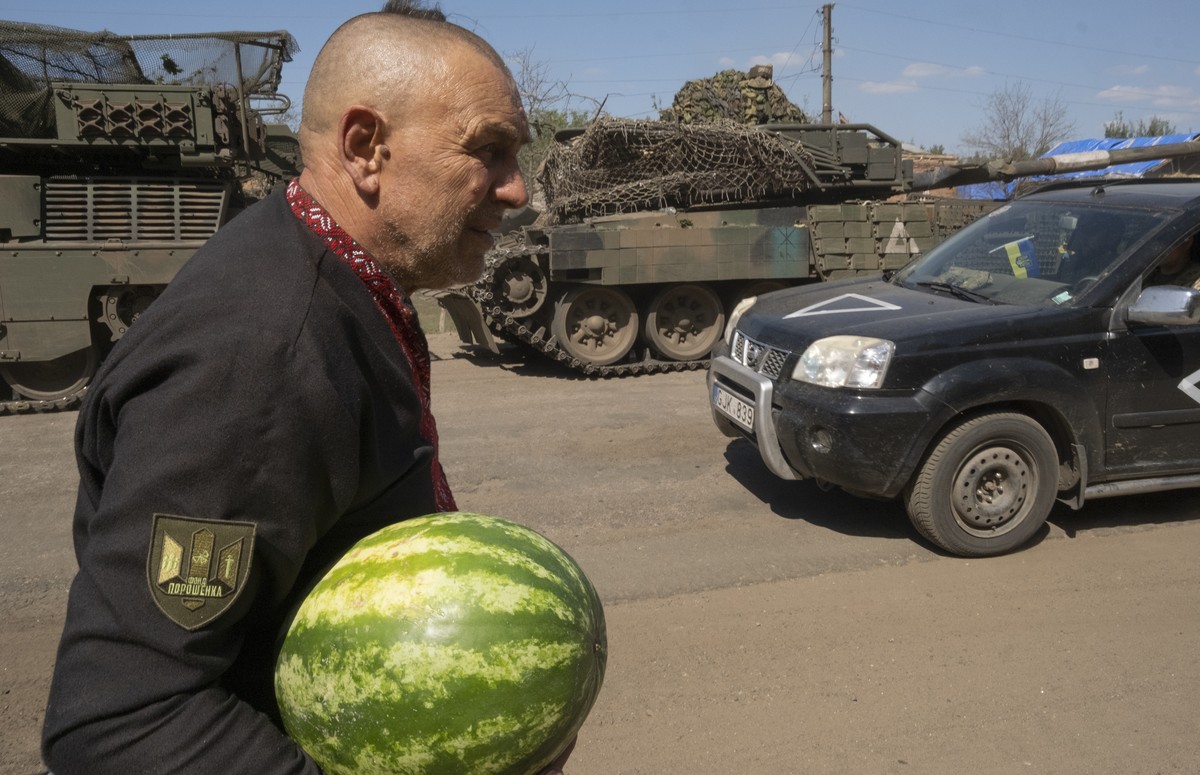epa11553569 A volunteer, father of a fallen Ukrainian soldier, and his granddaughter distribute watermelons and food to servicemen on a road in the Sumy region near the border with Russia, Ukraine, 17 ...