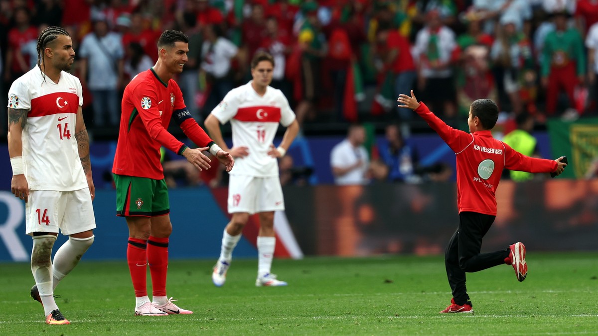 epa11430954 A children invades the pitch and runs towards Cristiano Ronaldo of Portugal during the UEFA EURO 2024 group F soccer match between Turkey and Portugal, in Dortmund, Germany, 22 June 2024.  ...