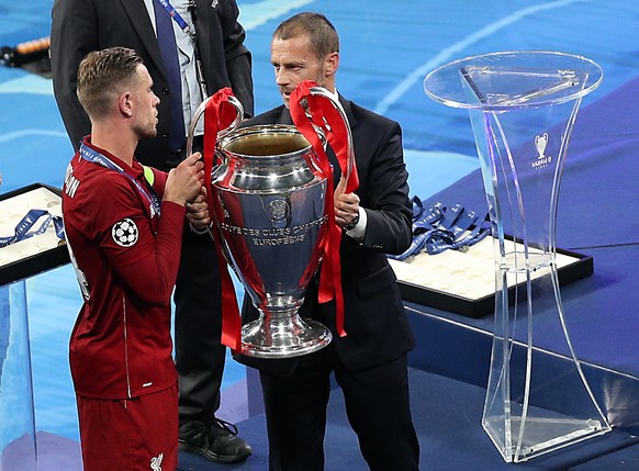 epa07619059 Liverpool&#039;s Jordan Henderson (L) receives the trophy from UEFA&#039;s President Aleksander Ceferin after the UEFA Champions League final between Tottenham Hotspur and Liverpool FC at  ...