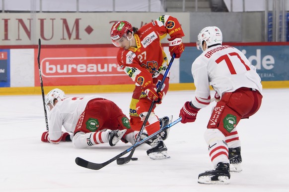 Lausannes Justin Krueger, links, Biels Yannick Rathgeb, Mitte, und Lausannes Robin Grossmann, rechts, kaempfen um den Puck, beim Eishockey Meisterschaftsspiel der National League zwischen dem EHC Biel ...
