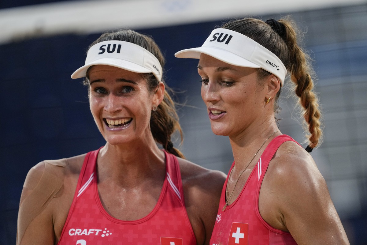 Joana Heidrich, of Switzerland, left, , celebrates with her teammate Anouk Verge-Depre, a winning point against Germany during a women's beach volleyball match, at the 2020 Summer Olympics, Satur ...