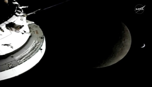 In this image from video provided by NASA, the Orion Spacecraft, the Earth and the Moon are seen from a camera as the Artemis II crew and spacecraft travel farther into Space, Monday, April 6, 2026. ( ...