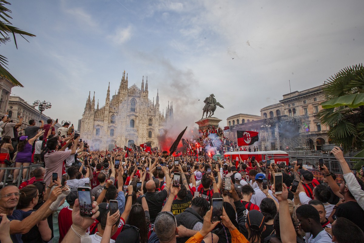AC Milan fans celebrate in Piazza Duomo square after a Serie A soccer match between Sassuolo and AC Milan, being played in Reggio Emilia, in Milan, Italy, Sunday, May 22, 2022. AC Milan secured its fi ...