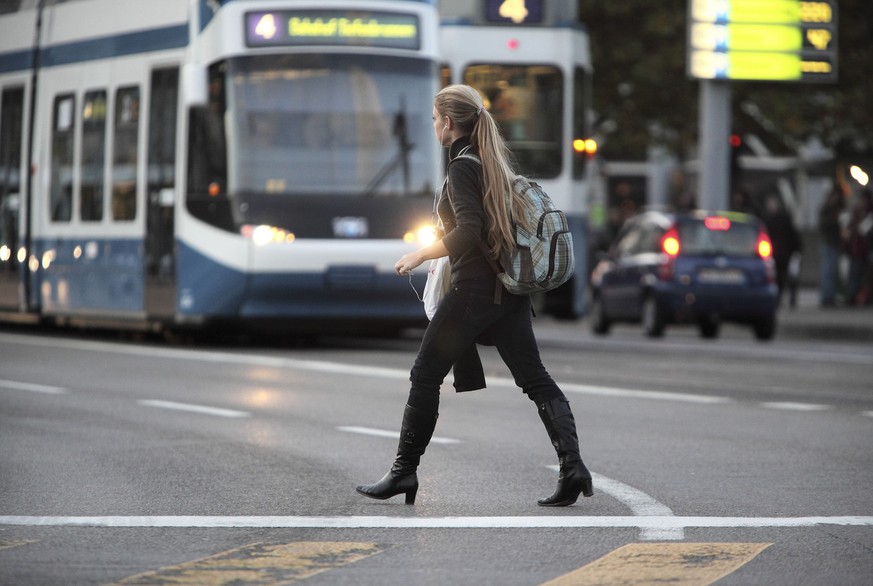 A young woman crosses the street while trams approach in the background in downtown Zurich, Switzerland, pictured on November 10, 2008. (KEYSTONE/Gaetan Bally)

Ein junge Frau ueberquert vor herannahe ...