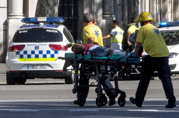 epa06148623 Mossos d&#039;Esquadra Police officers and emergency service workers move an injured man, after a van crashes into pedestrians in Las Ramblas, downtown Barcelona, Spain, 17 August 2017. Ac ...