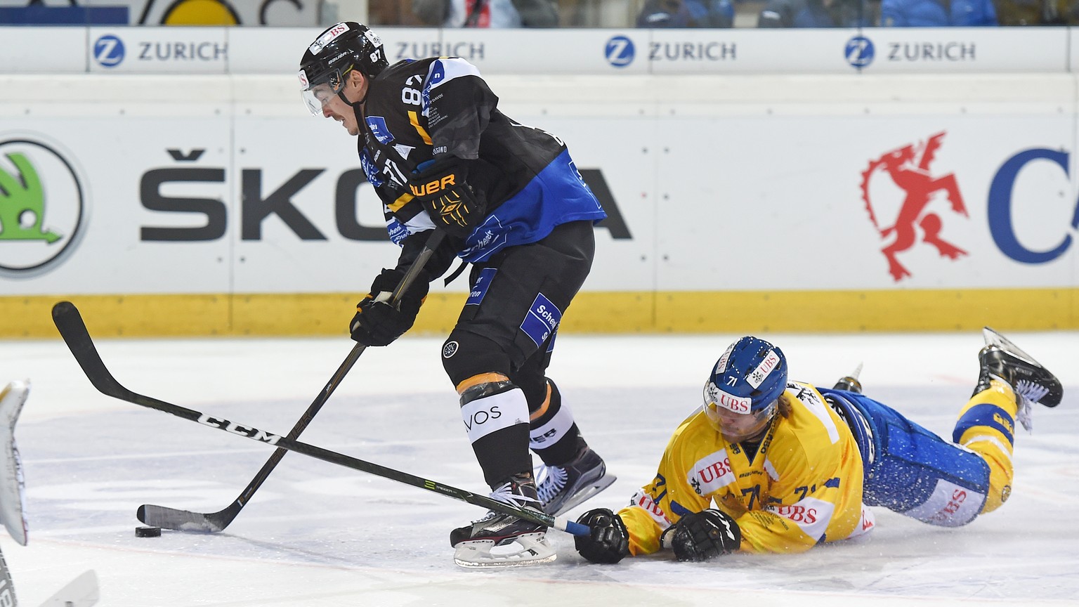 Davoss Claude-Curdin Paschoud, right, fights for the puck against Luganos Dario Buergler, left, during the game between Switzerlands HC Lugano and Switzerlands HC Davos at the 90th Spengler Cup ice ho ...