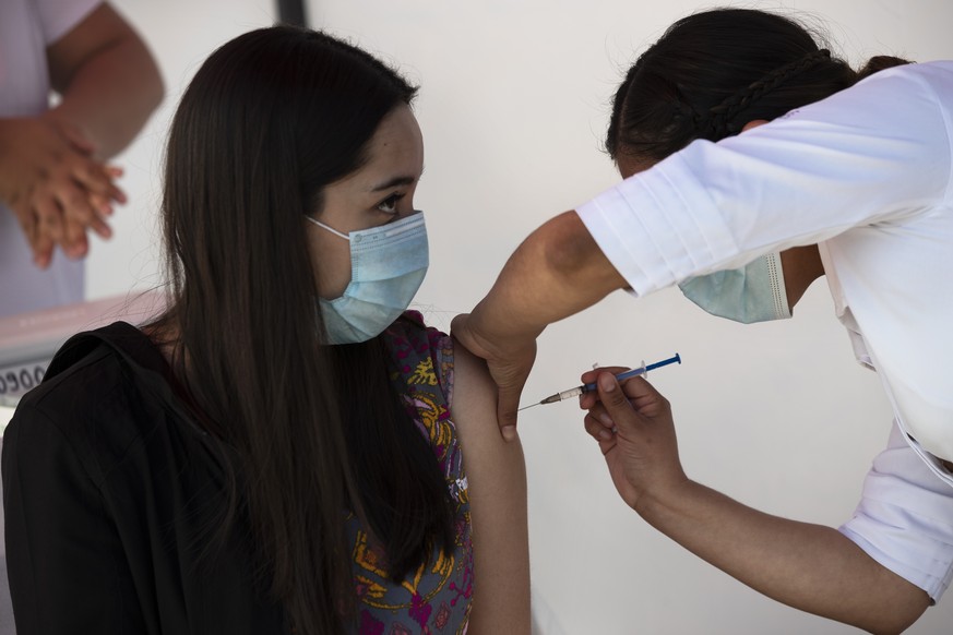 A health worker gets a shot of the Pfizer-BioNTech vaccine for COVID-19 at the N-1 military base in Mexico City, Wednesday, Dec. 30, 2020. (AP Photo/Marco Ugarte)