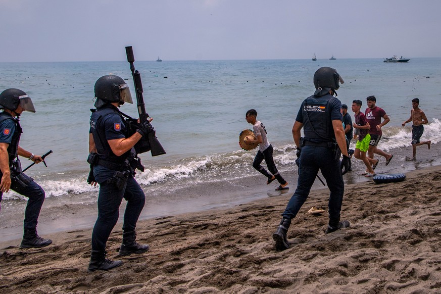 Spanish police officers respond as migrants cross from Morocco into the Spanish enclave of Ceuta, Thursday, July 30, 2026. (AP Photo/Antonio Sempere)
Spain Ceuta