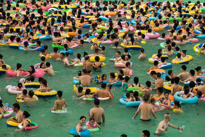 epa06105230 Chinese tourists with swim rings enjoy swimming in the lake called 'Dead sea of China' in a resort of Suining city, southwestern China's Sichuan province, 22 July 2017. More ...