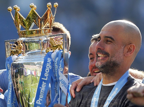 Manchester City coach Pep Guardiola lifts the English Premier League trophy after the English Premier League soccer match between Brighton and Manchester City at the AMEX Stadium in Brighton, England, ...