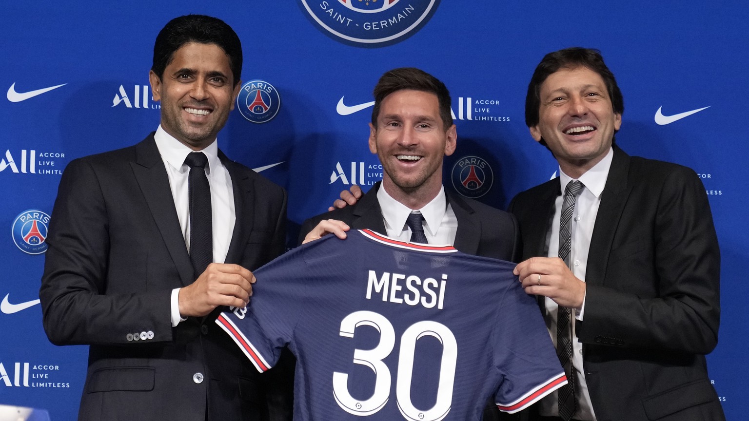 Lionel Messi, center, poses with his jersey with PSG president Nasser Al-Al-Khelaifi, left, and PSG sports director Leonardo during a press conference Wednesday, Aug. 11, 2021 at the Parc des Princes  ...