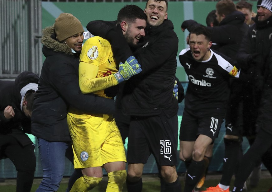 epa08936199 Kiel?s goalkeeper Ioannis Gelios (2-L) celebrates with teammates after winning the German DFB Cup second round soccer match between Holstein Kiel and FC Bayern Munich in Kiel, Germany, 13  ...