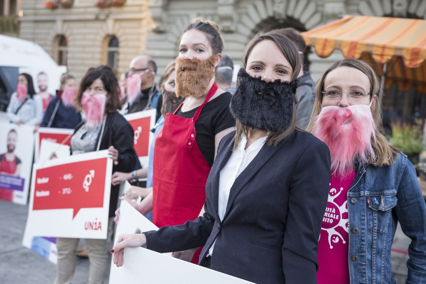 Corinne Schaerer, Geschaeftsleitungsmitglied der Gewerkschaft UNIA, rechts, hat sich zusammen mit Kolleginnen symbolisch einen Bart angeklebt, um ihrer Forderung nach Lohngleichheit zwischen den Gesch ...