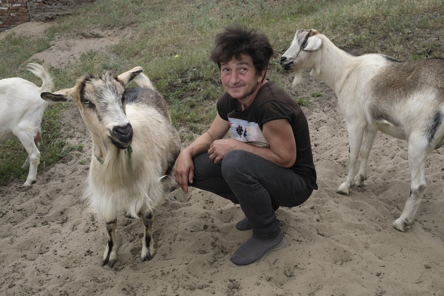 epa11333865 Natalia sits with her goats in the outskirts of Volchansk, Kharkiv region, Ukraine, 11 May 2024, amid the Russian invasion. Natalia, along with others, decided not to evacuate but remain i ...