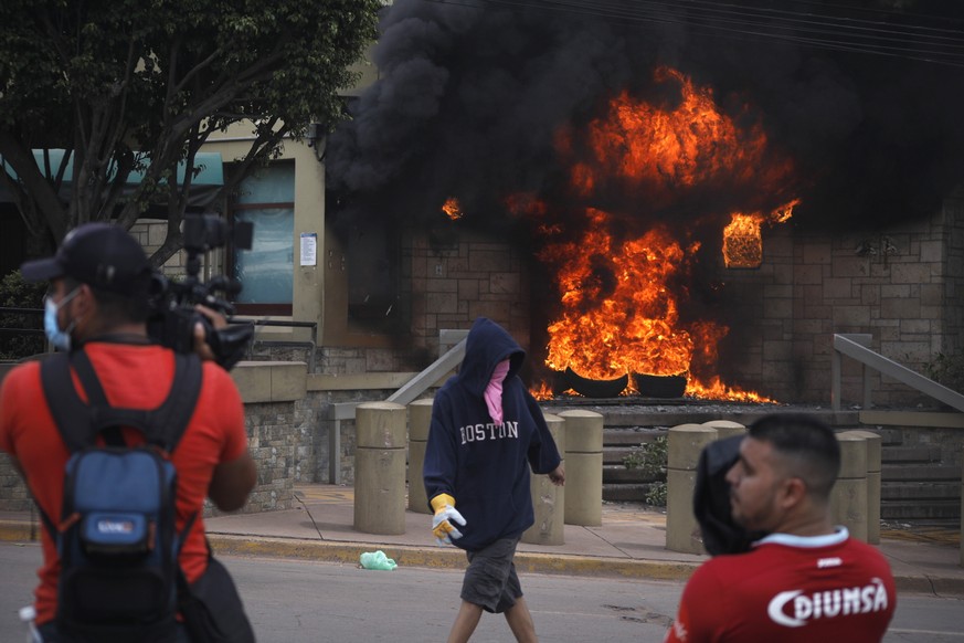 A tire fire started by protesters burns the main entrance into the U.S. Embassy during a protest against the government of President Juan Orlando Hernandez, in Tegucigalpa, Honduras, Friday, May 31, 2 ...