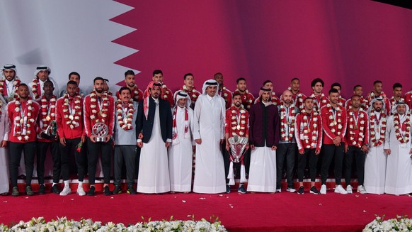 (190203) -- DOHA, Feb. 3, 2019 -- Qatar s Emir Sheikh Tamim bin Hamad Al Thani (C) welcomes the Qatari national soccer team upon arrival at Doha International Airport in Doha, Qatar on Feb. 2, 2019. Q ...