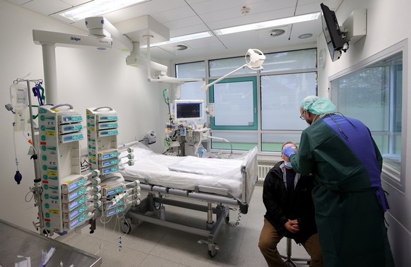 epa08761767 A doctor performs a COVID-19 Coronavirus test at the intensive care unit of the University Hospital in Essen, Germany, 21 October 2020. The University Hospital Essen treats several patient ...