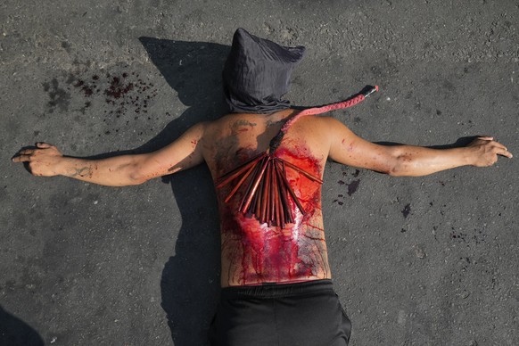 A hooded Filipino flagellant prays as part of Maundy Thursday rituals to atone for sins or fulfill vows for an answered prayer on April 6, 2023 at Mandaluyong city, Philippines. COVID restrictions the ...
