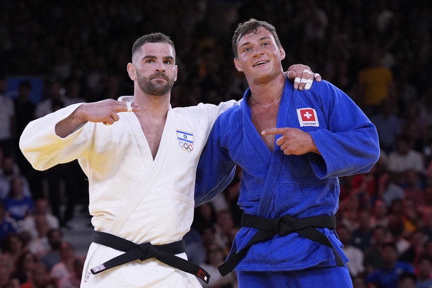 Israel&#039;s Peter Paltchik celebrates after defeating Switzerland&#039;s Daniel Eich, right, during their men&#039;s -100 kg bronze medal match in the team judo competition, at Champ-de-Mars Arena,  ...