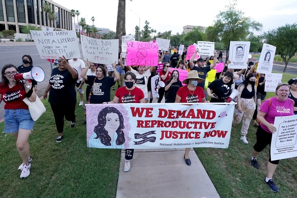 FILE - Thousands of protesters march around the Arizona Capitol in protest after the Supreme Court decision to overturn the landmark Roe v. Wade abortion decision Friday, June 24, 2022, in Phoenix. An ...