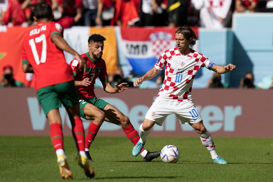 Croatia&#039;s Luka Modric (10) controls the ball against Morocco&#039;s Sofiane Boufal (17) and Noussair Mazraoui (3) during the World Cup group F soccer match between Morocco and Croatia, at the Al  ...