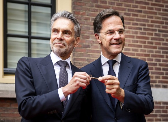 epa11451950 Former Dutch Prime Minister Mark Rutte (R) hands over the key of the Torentje, the Prime Minister&#039;s office, to new Prime Minister Dick Schoof (L) during the transfer of the premiershi ...