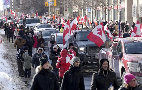 Trucks and supporters travel down Bloor Street during a demonstration in support of a trucker convoy in Ottawa protesting COVID-19 restrictions, in Toronto, Saturday, Feb. 5, 2022. (Nathan Denette/The ...