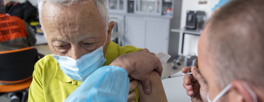 Un membre d&#039;une equipe mobile de vaccination de la protection civile vaudoise, PC, vaccine une homme a l&#039;aide du vaccin Pfizer-BioNTech dans les logements proteges Les Saules, lors du dernie ...