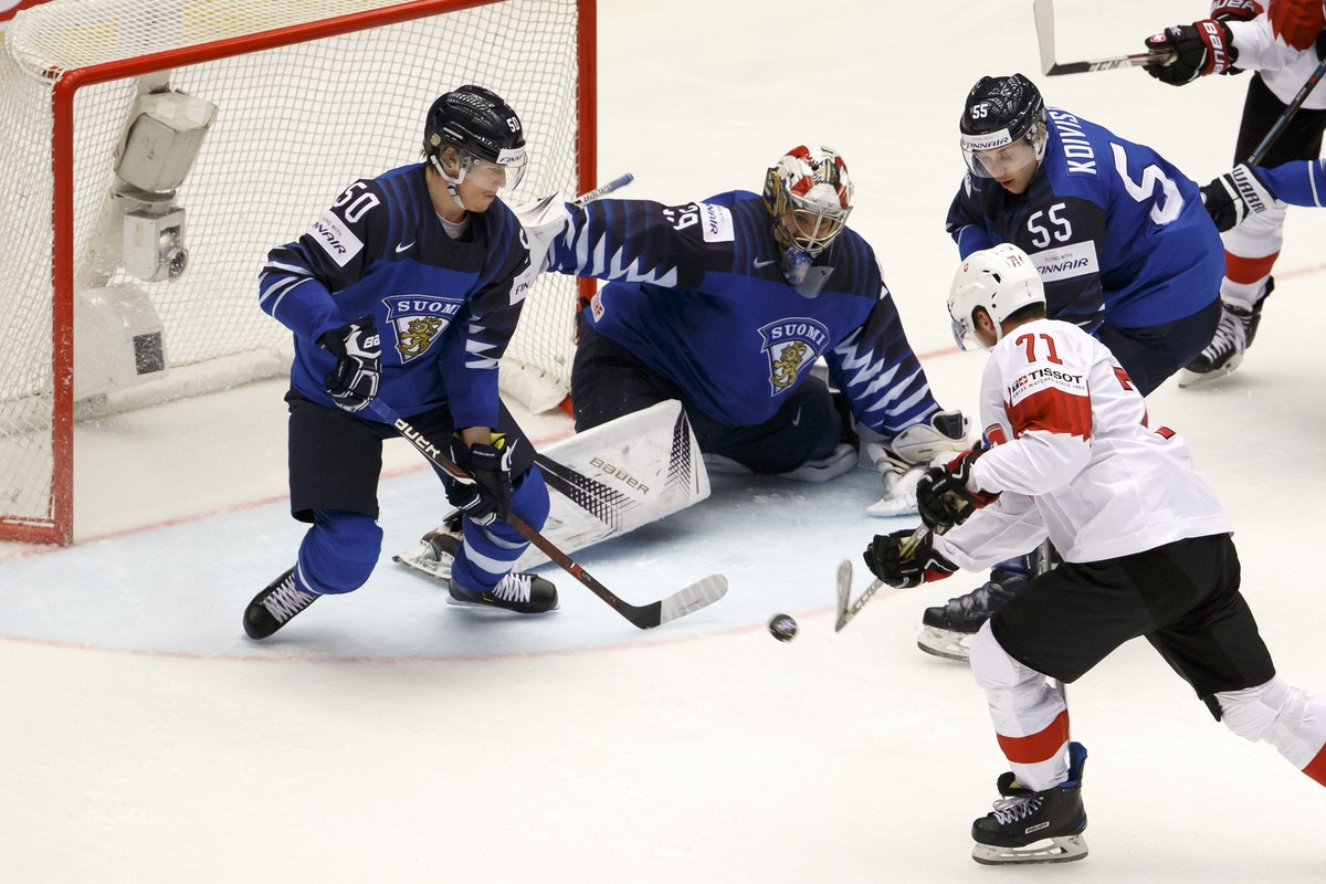 Switzerland's forward Enzo Corvi #71 scores the 1:1 against Finland's goaltender Harri Saeteri, 2nd left, past Finland's players defender Juuso Riikola, left, and defender Miika Koivist ...