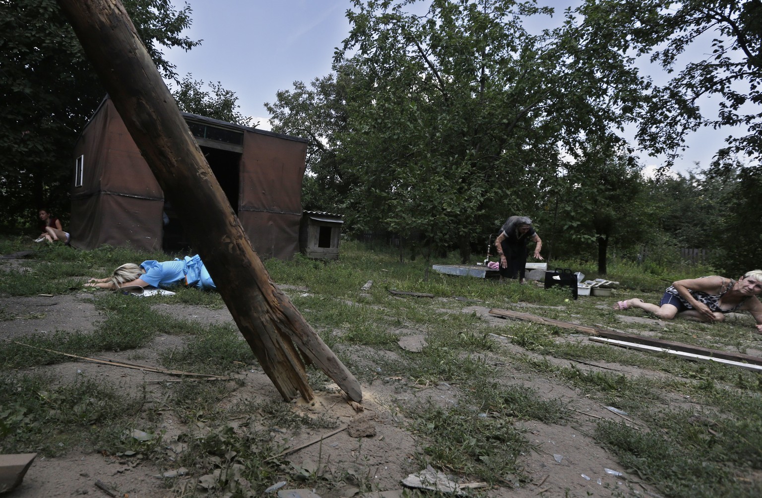 Frauen in Donezk werfen sich am Sonntag auf den Boden während Geschosse einschlagen.
