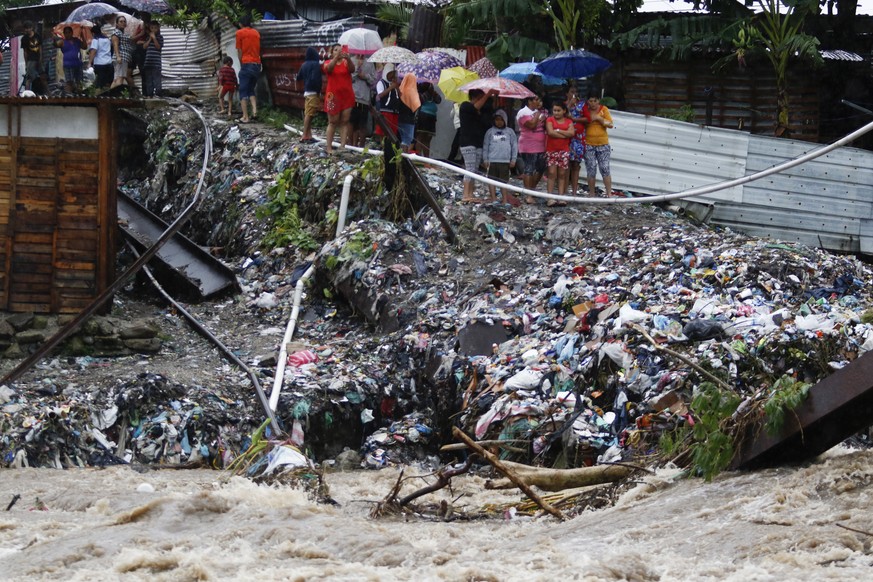 People watch the waters of the Rio Bermejo in the wake of Hurricane Iota in San Pedro Sula, Honduras, Tuesday, Nov. 17, 2020. Hurricane Iota tore across Nicaragua on Tuesday, hours after roaring ashor ...