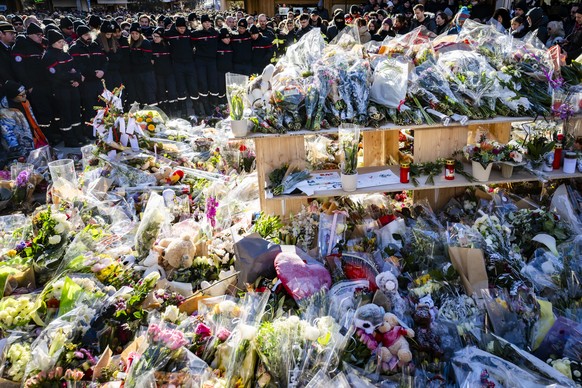 epa12625420 Firefighters of Crans-Montana, first responders in the fire at the "Le Constellation" bar and lounge, show emotions as they gather around flowers and candles to commemorate the v ...