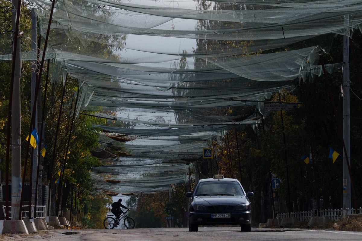 A local man rides a bicycle beneath anti-drone nets stretched over a street during a local ceasefire related to a humanitarian aid mission in Oleshky, in Kherson, Ukraine, Wednesday, Oct. 28, 2026. (A ...