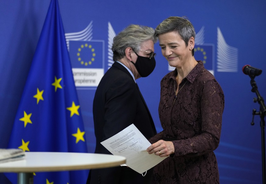 epa09738079 European Commissioner for Europe fit for the Digital Age Margrethe Vestager (R) passes by European Commissioner for Internal Market Thierry Breton as they participate in a signature ceremo ...