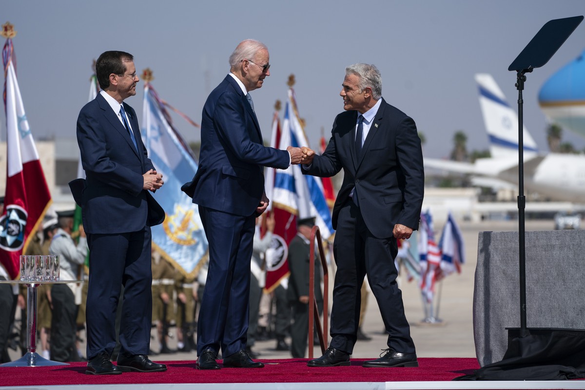 Israeli President Isaac Herzog, left, looks on as President Joe Biden gives a fist bump to Israeli Prime Minister Yair Lapid during an arrival ceremony after arriving at Ben Gurion Airport, Wednesday, ...