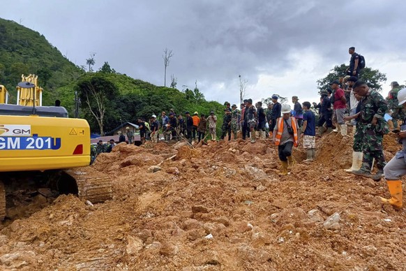 In this photo released by the Indonesian National Search and Rescue Agency (BASARNAS), rescuers search for victims at the site of a landslide in Suwawa on Sulawesi Island, Indonesia, Wednesday, July 1 ...