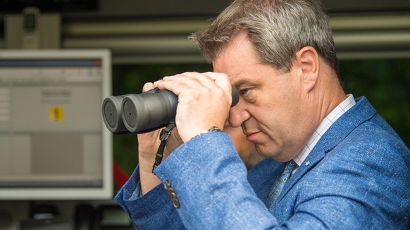 dpatopbilder - 18.07.2018, Bayern, Kirchdorf: Markus Söder (CSU), Ministerpräsident von Bayern, schaut während der Grenzkontrollen durch die bayerische Landespolizei am Grenzübergang Kirchdorf durch e ...