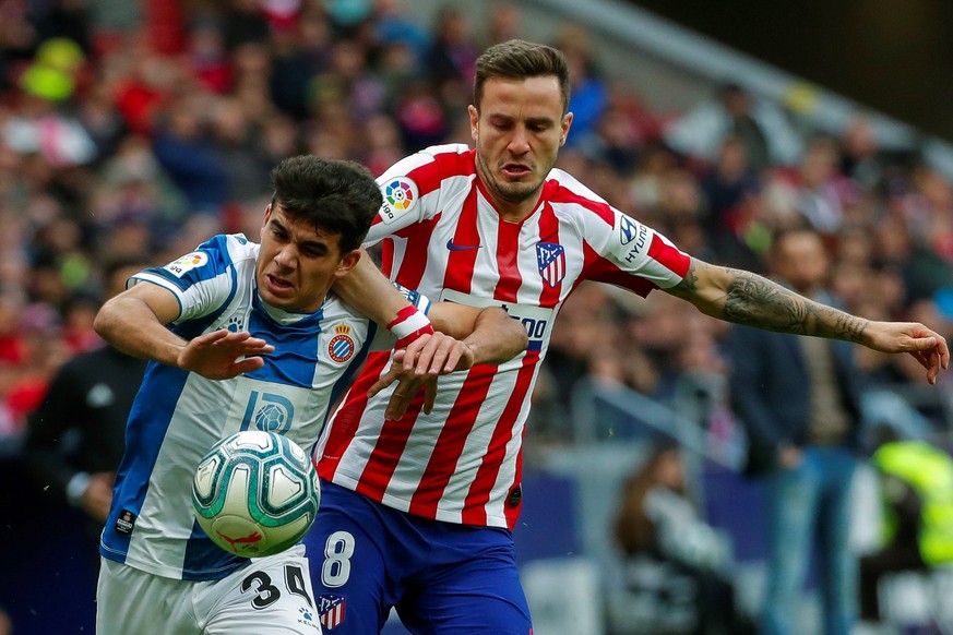 epa07986252 Atletico Madrid&#039;s midfielder Saul Niguez (R) duels for the ball with Espanyol&#039;s Victor Gomez (L) during their Spanish LaLiga Primera Division soccer match played at the Wanda Met ...