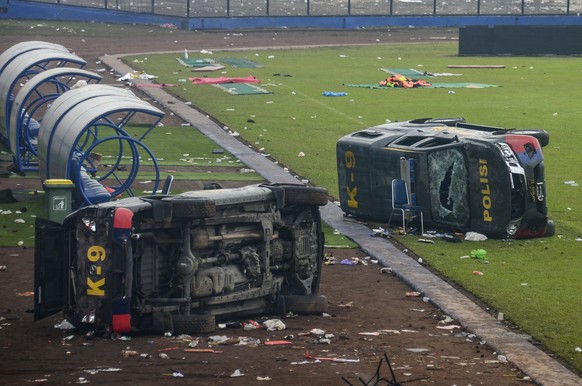 epaselect epa10218863 Damaged police vehicles lay on the pitch inside Kanjuruhan stadium in Malang, East Java, Indonesia, 02 October 2022. At least 127 people including police officers were killed mos ...