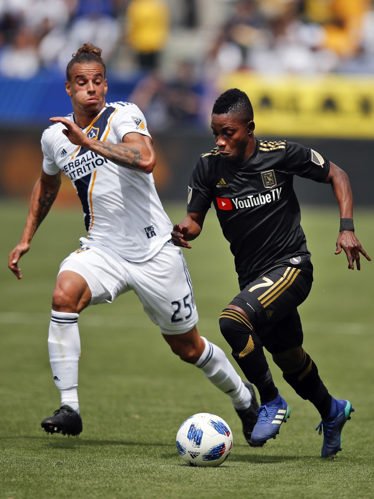 Los Angeles FC's Latif Blessing, right, dribbles the ball past Los Angeles Galaxy's Rolf Feltscher, of Switzerland, during the first half of an MLS soccer match Saturday, March 31, 2018, in  ...