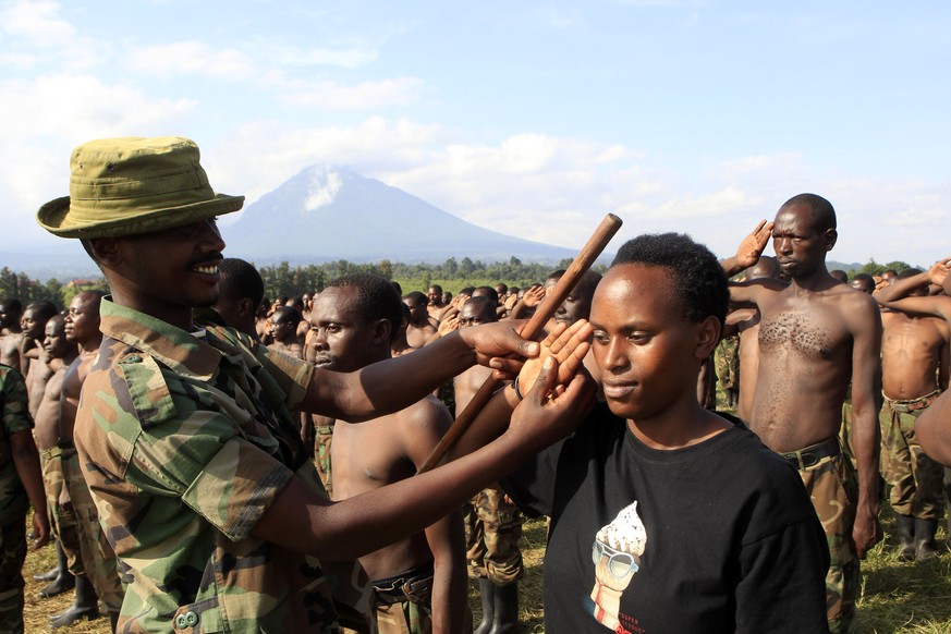 Ein Offizier unterrichtet eine Rekrutin der kongolesischen Guerilla M23 im Salutieren.