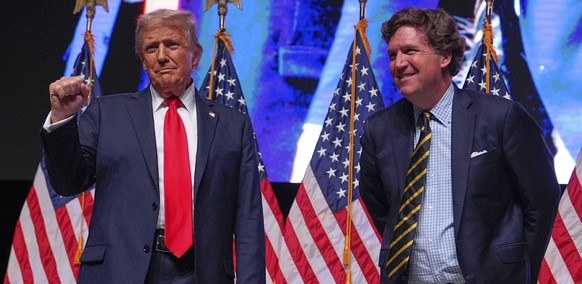 FILE - Republican presidential nominee former President Donald Trump speaks with Tucker Carlson during a Tucker Carlson Live Tour show at Desert Diamond Arena, Oct. 31, 2024, in Glendale, Ariz. (AP Ph ...