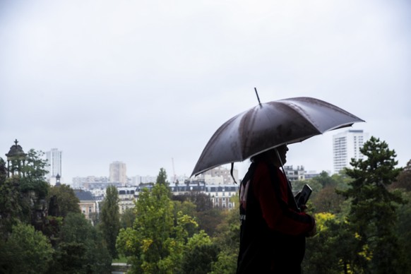 epa11650940 A man with an umbrella walks in the Buttes Chaumont park in Paris, France, 09 October 2024. Storm Kirk has caused major disruptions in France&#039;s southwest, resulting in high winds and  ...