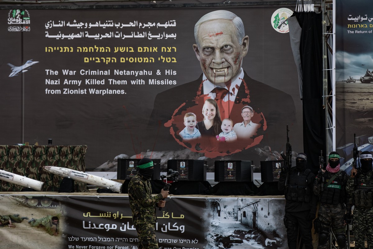 epa11909255 The coffins containing the bodies of Sheri Bibas, her two children, Ariel and Kfir, and Oded Lifshitz, sit on a stage before being handed over to the Red Cross by Hamas in Khan Yunis, sout ...