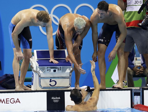 United States' Townley Haas, Ryan Lochte and Conor Dwyer, from left, celebrate as Michael Phelps, bottom, finishes to win the gold medal in the men's 4x200-meter freestyle final during the swimming competitions at the 2016 Summer Olympics, Tuesday, Aug. 9, 2016, in Rio de Janeiro, Brazil. (AP Photo/Michael Sohn)