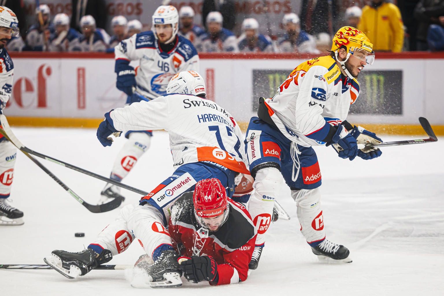 L&#039;attaquant lausannois Tim Bozon, centre, chutte alors qu&#039;il lutte pour le puck avec le defenseur des ZSC Scott Harrington, gauche, et le Top Scorer PostFinance des ZSC Sven Andrighetto, dro ...