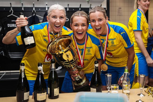 191215 Anna Wijk, Alice Granstedt and Alice Granstedt of Sweden celebrate in the locker room with the trophy after the women™s World Floorball Championship final game between Sweden and Switzerland on ...