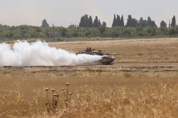 epa11357601 An Israeli army tank maneuvers along the border fence with the Gaza Strip, at an undisclosed location in southern Israel, 21 May 2024. The Israeli military stated on 21 May that they conti ...